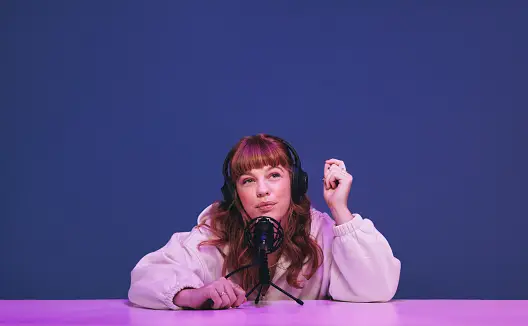 a woman doing a podcast in front of a purple background